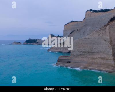 Spettacolare paesaggio costiero di Capo Drastis, Corfù, Grecia, con il Mar Ionio turchese e le scogliere calcaree erose al tramonto Foto Stock