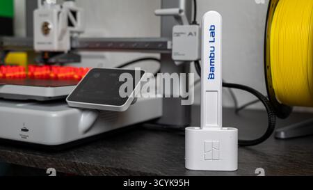 Jurmala, Lettonia - 14.10.2025: Primo piano stampante 3D Bambu Lab A1 con AMS. Configurazione della stampa 3D con filamento e un display vicino alla workstation in una Foto Stock
