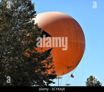 IRVINE, CALIFORNIA - 11 ottobre 2025: The Great Park Balloon Ride decorato per Halloween sembra giocare a cucù intorno a un albero. Foto Stock