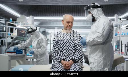 Esperto in una tuta protettiva studia la risposta immunitaria su pazienti infetti in quarantena, sperimentando nuovi vaccini e trattamenti antivirali per combattere il disastro globale e la crisi sanitaria. Telecamera A.. Foto Stock