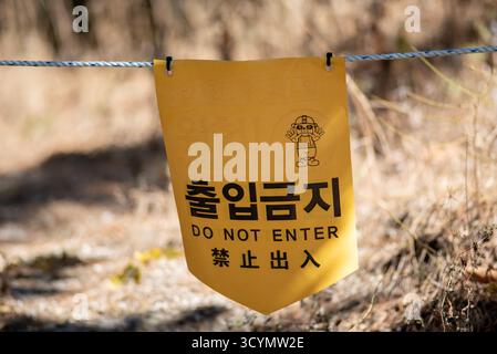 Cartello di avvertimento giallo con testo coreano e inglese non entrare appeso su una corda all'aperto a Seoul, Corea del Sud, il 5 novembre 2022 Foto Stock