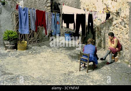Perugia, Italia, 1981. Le donne locali parlano in modo causale in un cortile, con asciugatura su stoffa. Foto Stock