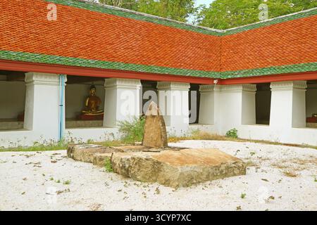 Il cortile interno e il chiostro fiancheggiati da numerose immagini di Buddha di Wat Phra Mahathat Woramahawihan, Nakhon si Thammarat, Thailandia Foto Stock