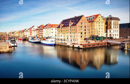 Canale fluviale con molte barche e navi con piccole vecchie case nella zona di Christianshavn a Copenaghen, Danimarca Foto Stock