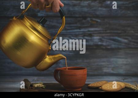Il tè Masala è in fase di versamento in tazze di fango note come Kulhad. Localmente chiamato Kulhad chai o tagliando chai o masala chai o tè matka. Foto Stock