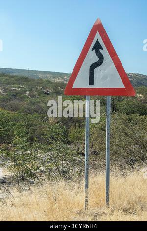 Un cartello curva sulla C35 vicino a Ruacana nel nord della Namibia. Foto Stock