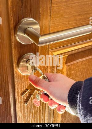 Porta in legno con chiave argento per sbloccare a mano Foto Stock