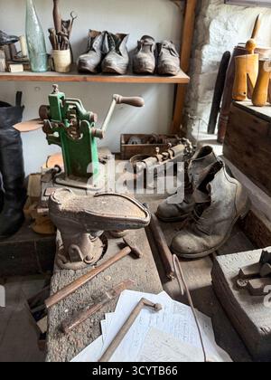 Un'epoca passata di un vecchio laboratorio di calzolai con scarpe e attrezzi in un piccolo museo di campagna locale all'aperto in un villaggio di Hutt nel North Yorkshire Foto Stock