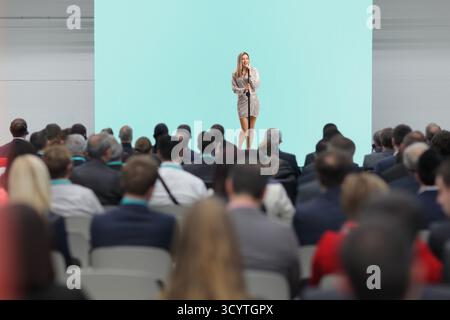 Cantante femminile sul palco che canta davanti a persone nel pubblico Foto Stock