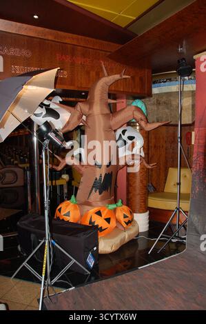 Decorazioni gonfiabili di Halloween caratterizzate da un albero spettrale con volti fantasma e zucche, collocate all'interno vicino alle luci dello studio fotografico e all'area del casinò Foto Stock