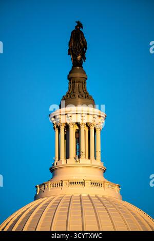 Statua della Libertà sul cupolone del Campidoglio degli Stati Uniti Washington DC | WASHINGTON D.C., Stati Uniti — Vista quasi in silhouette contro un cielo serale limpido, la statua di bronzo della Libertà si erge in cima al lanternino del cupolone del Campidoglio degli Stati Uniti. Scultorea di Thomas Crawford e installata nel 1863, la figura misura 19 piedi e 6 pollici (6 m) di altezza e pesa circa 15.000 libbre (6.800 kg), coronando una cupola in ghisa completata nel 1866. Foto Stock