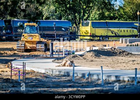 Tidal Basin Seawall Construction Project Washington DC // WASHINGTON DC — i progressi nel Tidal Basin Seawall Construction Project sono visibili il 17 ottobre 2025, mostrando un bulldozer e un percorso in cemento appena posato. Questa vista viene catturata accanto al Jefferson Memorial, guardando attraverso il bacino di marea verso l'Inlet Bridge. L'ampio progetto prevede la riparazione e l'innalzamento dei fondali marini che si deteriorano intorno al bacino delle Tidal. Questo importante lavoro infrastrutturale mira a mitigare le frequenti inondazioni causate dalle alte maree e dall'innalzamento del livello del mare, proteggendo i monumenti e i ciliegi iconici della zona. Foto Stock