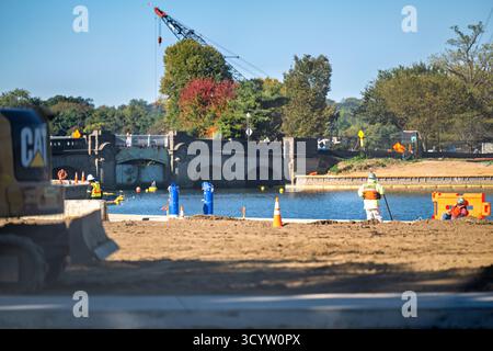 Tidal Basin Seawall Construction Project Washington DC // WASHINGTON DC — i progressi nel Tidal Basin Seawall Construction Project sono visibili il 17 ottobre 2025, vicino al Jefferson Memorial. Sono presenti operai edili e attrezzature pesanti, il che indica gli sforzi continui per riparare le dighe deteriorate. Questa riabilitazione pluriennale, gestita dal National Park Service, affronta importanti sfide di cedimento e inondazione che interessano gli iconici alberi di ciliegio e le infrastrutture circostanti. La vista e' da vicino al Thomas Jefferson Memorial, guardando attraverso il bacino di marea verso la t Foto Stock