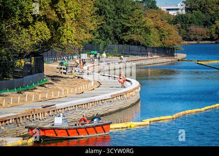 Tidal Basin Seawall Construction Project Washington DC // WASHINGTON DC — Tidal Basin Seawall Construction Project Progress è visibile il 17 ottobre 2025, mostrando una sezione di recente costruzione della diga e del sentiero. Questo progetto infrastrutturale vitale affronta il problema del cedimento e delle inondazioni marittime, proteggendo i monumenti iconici intorno al bacino delle maree. La vista è dall'Inlet Bridge, guardando a nord-est verso il National Mall, uno spazio verde centrale a Washington DC. Il Franklin Delano Roosevelt Memorial è situato dietro gli alberi sulla sinistra, un punto di riferimento importante nel West Potomac Park. Foto Stock