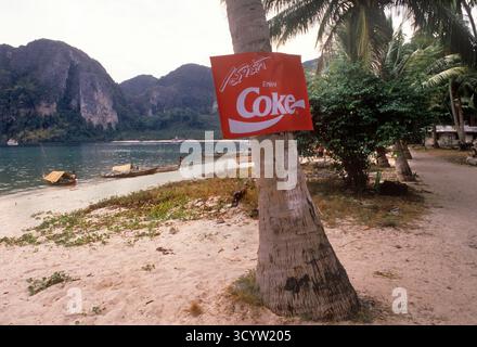 Ko Phi Phi Don Island, Loh Dalam Bay - North Beach. Cartello pubblicitario della Coca Cola sulla spiaggia. Barche degli zingari di mare con tettoie per proteggerli dal sole ai bordi delle acque. Krabi, Tailandia Sud Est Asiatico 1995 1990s HOMER SYKES Foto Stock