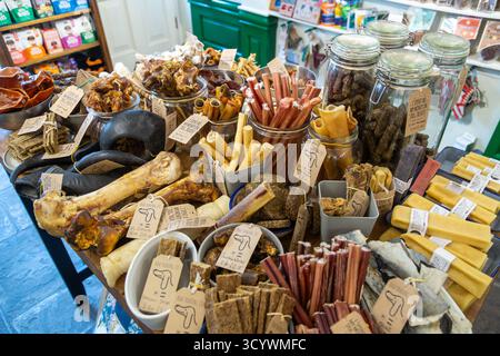 Un tavolo pieno di prelibatezze per cani, tra cui ossa di struzzo e strisce di cervo. Foto Stock