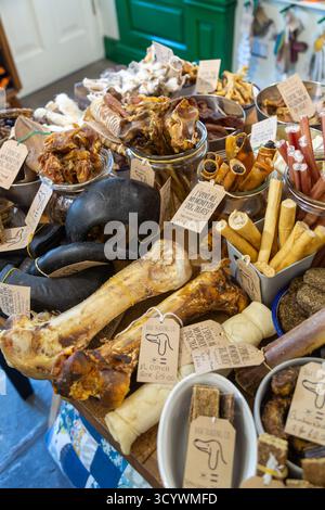 Un tavolo pieno di prelibatezze per cani, tra cui ossa di struzzo e strisce di cervo. Foto Stock