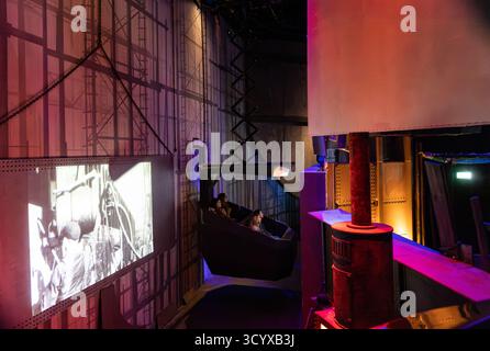 I visitatori che sperimentano lo storico simulatore interattivo di nave del Titanic con proiezioni in bianco e nero all'interno di una mostra del museo a Belfast Foto Stock