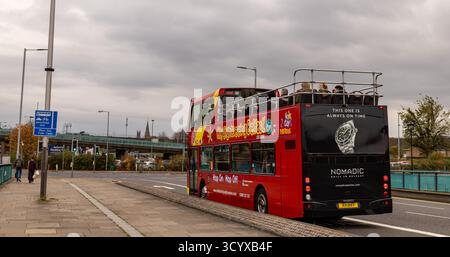 Autobus turistico rosso scoperto Hop-On Hop-Off di Belfast sotto il cielo coperto con i passeggeri sul ponte superiore Foto Stock