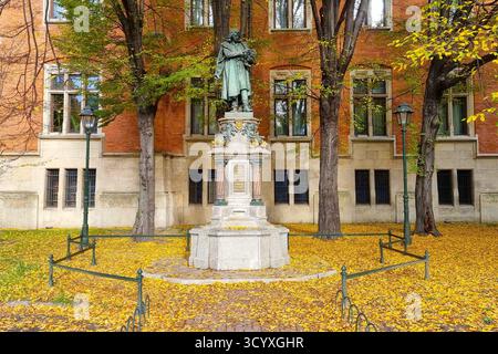 Monumento a Nicolaus Copernico di fronte all'edificio dell'Università Jagellonica, circondato dal fogliame autunnale di Cracovia, Polonia Foto Stock