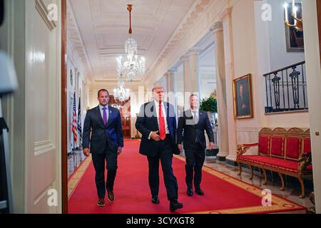 Washington DC, Stati Uniti. 20 ottobre 2025. Il presidente DEGLI STATI UNITI Donald Trump, al centro, affiancato da Brad Neffendorf, LSU Shreveport Pilots Head Coach, Left, e Jay Johnson, LSU Tigers Head Coach, Right, arriva per partecipare a una visita con i campioni LSU e LSU Shreveport Baseball nella East Room della Casa Bianca a Washington, DC, USA, il 20 ottobre 2025. Foto di Yuri Gripas/Pool/Sipa USA credito: SIPA USA/Alamy Live News Foto Stock