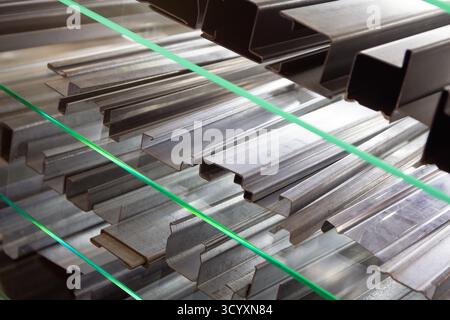Una varietà di profili in alluminio sulla vetrina di un negozio di costruzioni. Industria Foto Stock