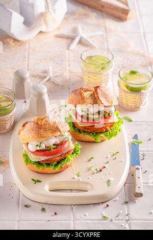 Hamburger di pesce fresco come sano spuntino per il pranzo. Hamburger di pesce con verdure e pesce. Foto Stock