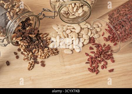 Selezione di noci con mandorle sgusciate crude, ribes nero, noci intere e bacche di goji su pangrattato Foto Stock
