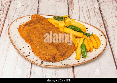 Cachopo lombato ripieno di prosciutto di York e formaggio Emmental, servito con patate al forno e salsa di funghi selvatici Foto Stock