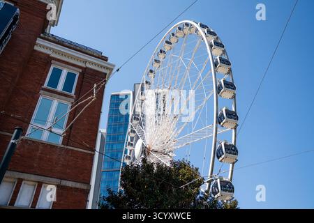 La ruota panoramica SkyView Atlanta sorge accanto agli storici edifici in mattoni e alle moderne torri di vetro sotto un cielo blu luminoso nel centro di Atlanta Foto Stock