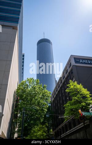 Il Westin Peachtree Plaza sorge sopra Williams Street e l'American Hotel, con la sua facciata in vetro riflettente che risplende su un cielo primaverile azzurro Foto Stock