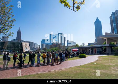 I visitatori si allineano fuori dal World of Coca-Cola nel centro di Atlanta in una mattinata limpida, con moderni grattacieli sullo sfondo Foto Stock