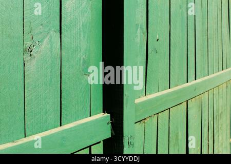 Recinzione in legno verde con ombre e linee Foto Stock
