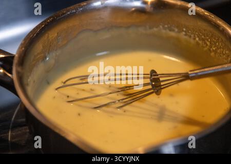 Frullare la salsa di bearnaise in una padella Foto Stock