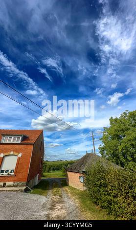 Bergnicourt, Rethel, Ardenne, Grand-Est, Francia, 28 agosto 2025, Una splendida e pittoresca scena di campagna che mostra un cielo vibrante e colorato insieme ad affascinanti strutture rustiche Foto Stock