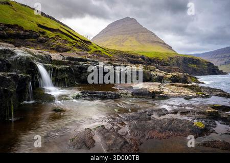 Vista della costa selvaggia vicino al villaggio di Eidi. Isola di Eysturoy, Isole Faroe, Danimarca, Europa. Foto Stock