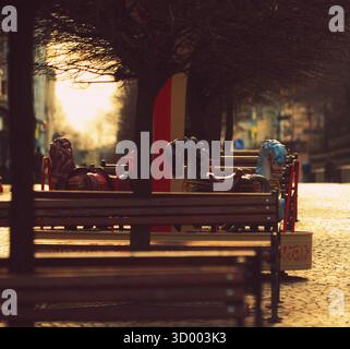 Una giostra con piccoli cavalli visibile lungo la strada che si affaccia sulla città di mаin Foto Stock