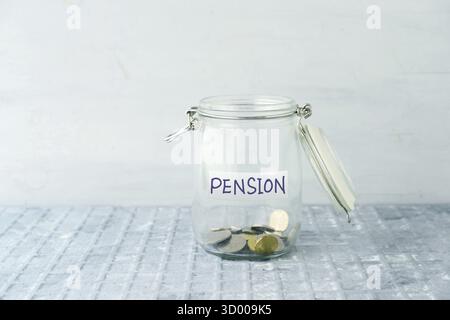 Monete in vaso di vetro con etichetta pensione, concetto finanziario Foto Stock