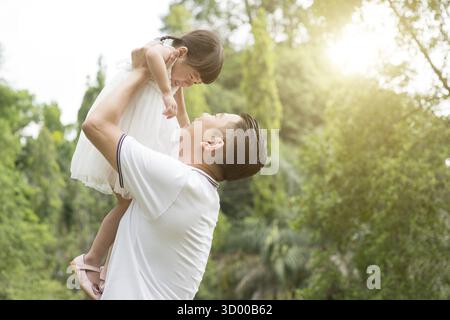 Ritratto di famiglia asiatica all'aperto. Padre e figlia si legano al Green Park Foto Stock