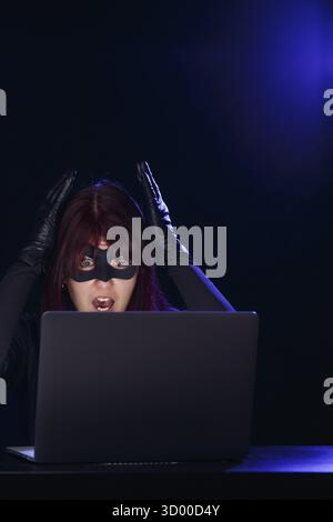 Giovane hacker bruna con laptop di notte Foto Stock