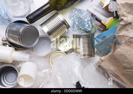 Diversi rifiuti riciclabili giacciono su un tavolo bianco Foto Stock