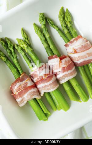 Asparagi verdi al forno con pancetta e spezie. Cibo molto gustoso e sano. Vista dall'alto. Foto verticale Foto Stock