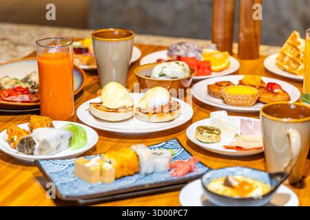Colazione di lusso con uova benedict, pasticcini, sushi, Foto Stock