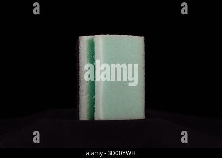 pulitore a spugna per cucina singolo blu pallido verde isolato su sfondo nero Foto Stock