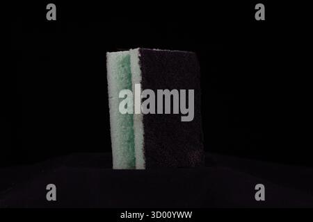 pulitore a spugna per cucina singolo blu pallido verde isolato su sfondo nero Foto Stock