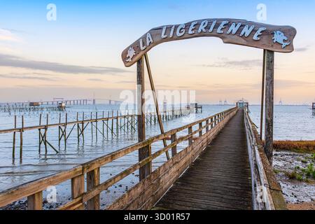 Francia, Loira Atlantica, Saint-Brevin-les-Pins, capanne di pesca o di pescatori lungo l'estuario della Loira, ponte di Saint-Nazaire sullo sfondo Foto Stock