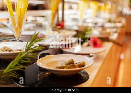 Un vivace buffet propone una varietà di piatti, tra cui antipasti e insalate, disposti elegantemente in un locale da pranzo. Foto Stock