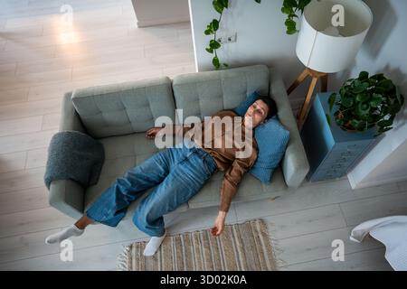 La donna matura sgocciolata si trova immobile sul divano sopraffatta da stanchezza mentale e dolore a casa Foto Stock
