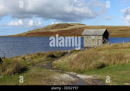 Old Remote Stone Boathouse on Devoke Water nel Lake District National Park, Cumbria, Inghilterra, Regno Unito. Foto Stock
