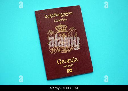 Libretto dei passaporti georgiani su sfondo di carta blu chiaro primo piano. Documento di viaggio su superficie blu Foto Stock